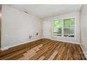 Living room with hardwood floors, a white door, and natural light streaming through large windows at 5143 Delivau Dr, Charlotte, NC 28215