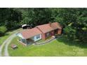 Aerial view of a well-maintained home with large yard, mature trees and detached outbuilding at 7016 Tirzah Rd, Waxhaw, NC 28173