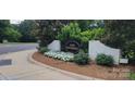 Well-maintained community entrance sign with lush greenery and floral accents at 7017 Knightswood Dr, Charlotte, NC 28226