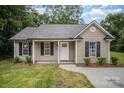 Charming one-story home featuring black shutters, a welcoming front porch and manicured landscaping at 903 Brookdale St, Kannapolis, NC 28083