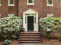 Close up view of the brick home's front door and manicured landscaping at 9415 Braemar Ter, Charlotte, NC 28210