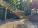 Carport area with gravel driveway and brick retaining wall and boat stored underneath at 110 Indian Harbor Cir, Mount Gilead, NC 27306
