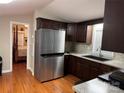 A kitchen with dark wood cabinets, stainless steel refrigerator, and light countertops at 110 Indian Harbor Cir, Mount Gilead, NC 27306