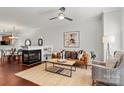 Cozy living room with a fireplace, ceiling fan and a stylish rug over hardwood flooring at 1125 Kurt Ct, Charlotte, NC 28209