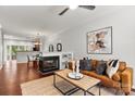 Cozy living room with fireplace, hardwood flooring, ceiling fan, and open to the dining area at 1125 Kurt Ct, Charlotte, NC 28209