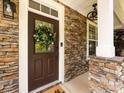 Inviting front door with decorative wreath and stone accents create a warm and welcoming entry at 12928 Windy Lea Ln, Huntersville, NC 28078