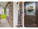 Close-up of the charming front door with stone accents and a welcoming sign, offering a warm, inviting entrance at 132 Sycamore Crossing Ct, Locust, NC 28097