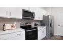 Well-lit kitchen boasting white cabinets, stainless steel appliances, and elegant countertops at 1386 6Th Street Ne St, Hickory, NC 28601