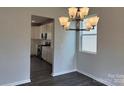 Elegant dining room features a modern chandelier and a view into the adjacent kitchen area at 152 Ella Claire Dr, York, SC 29745