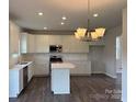 Bright kitchen boasts white cabinetry, stainless steel appliances, and a large island for meal prep at 152 Ella Claire Dr, York, SC 29745