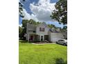 Inviting two-story home with manicured lawn, red front door, and attached garage, perfect for Gathering living at 1902 Stonewyck Ave, Kannapolis, NC 28081