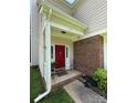 Charming covered front porch with brick accents and bright red door, creating a welcoming entrance at 1902 Stonewyck Ave, Kannapolis, NC 28081