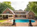Spacious backyard with inviting pool, covered patio, and brick surround, perfect for entertaining at 1933 Tara Trl, Lancaster, SC 29720