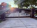 A wrought iron driveway gate with stone pillars adds elegance to this property at 21035 Coley Store Rd, Locust, NC 28097