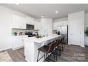 Modern kitchen features white cabinetry, stainless steel appliances, and a spacious island with seating at 219 Parker Claire Ln, Kings Mountain, NC 28086