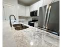 Modern kitchen featuring stainless steel appliances, white cabinets, and marble countertops at 219 Pine St, Rockwell, NC 28138