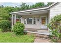 Charming front porch with classic white trim and a natural wood door at 2722 Eastway Dr, Charlotte, NC 28205