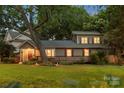 Charming two-story home with a covered front porch, mature trees, and illuminated exterior lighting at 2800 Georgia Ave, Charlotte, NC 28205