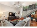 Stylish living room with a gray sectional sofa, modern TV, and staircase with metal railings at 297 Mcdonald Ave, Charlotte, NC 28203