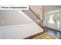 Bright entryway showcasing a staircase with wooden and iron details and a decorative rug on hardwood floors at 3122 Spring Iris Dr, Denver, NC 28037