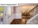 Elegant foyer with a staircase, hardwood floors, and a decorative glass front door showcasing the dining room at 3122 Spring Iris Dr, Denver, NC 28037