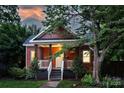 Inviting red home with classic porch and well-maintained yard at dusk at 3519 Card St, Charlotte, NC 28205