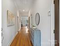 Bright hallway with hardwood floors, neutral walls, and decorative furnishings leading into the main living spaces at 3519 Card St, Charlotte, NC 28205