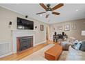 Comfortable living room with a brick fireplace, mounted TV, and hardwood floors at 3612 Trent St, Charlotte, NC 28209