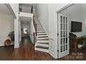 Elegant foyer with hardwood floors, staircase with wood banister and iron spindles, and open doorway at 3913 Widgeon Way, Waxhaw, NC 28173