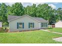 Quaint home featuring neat lawn, blue shutters, and a welcoming pathway to the front door at 425 Austin Dr, Charlotte, NC 28213