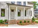Inviting front porch with white columns and brick accents on a modern home at 513 Sacco St, Belmont, NC 28012