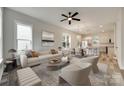 Open-concept living room with neutral decor and abundant natural light from windows at 513 Sacco St, Belmont, NC 28012