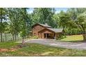 Charming log home with a porte cochere, surrounded by lush greenery and serene lake views, a true retreat at 6836 Summer Hill Dr, Denver, NC 28037