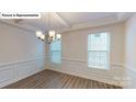 Formal dining room with wood floors, chandelier, coffered ceiling, and wainscoting at 7172 Sylvan Retreat Dr, Denver, NC 28037
