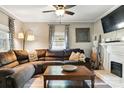 Cozy living room with a brown sectional sofa, fireplace, and a ceiling fan at 840 10Th Street Nw Blvd, Hickory, NC 28601