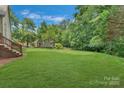 Large, lush backyard provides privacy with mature trees and lush greenery, perfect for relaxing outdoors at 9040 Scottsboro Dr, Huntersville, NC 28078
