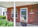 Close-up of brick porch, door, and window with view of street; shows home's address at 10078 Pergola View Ct, Charlotte, NC 28213