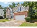 View of a two-story house with red brick, light-colored siding, a driveway, and an attached garage at 116 Scottie Ct, Rock Hill, SC 29730