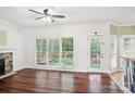Bright living room with a stone fireplace, hardwood floors, and large windows overlooking the backyard at 116 Scottie Ct, Rock Hill, SC 29730