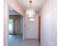 Inviting entryway with a chandelier, wallpaper, and view to the adjacent living room at 1216 Manchester Ln, Charlotte, NC 28227