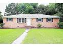 Charming brick home featuring a well-manicured lawn and inviting walkway at 1227 Flowe Dr, Matthews, NC 28104