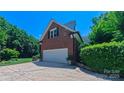 Spacious two-car garage attached to the brick home with a well-manicured lawn at 1240 Fawn Ridge Nw Rd, Concord, NC 28027