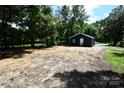 A large cleared lot shows a view of the home's rear, surrounded by mature trees at 1406 Caldwell St, Gastonia, NC 28052