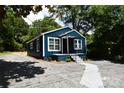 A lovely home featuring a new blue paint job, white trim, covered entry and refreshed landscaping at 1406 Caldwell St, Gastonia, NC 28052