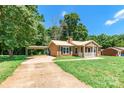 Cozy brick home with a metal roof, carport, and lush green lawn at 142 Single Oak Dr, Troutman, NC 28166