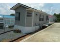 This home is a single-story structure with gray siding, black shutters, and a concrete perimeter surrounding the property at 166 Eagle Dr, New London, NC 28127