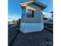 Exterior view showing a side of a manufactured home with blue sky backdrop at 166 Eagle Dr, New London, NC 28127