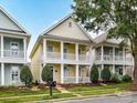 Charming two-story home with double porches, yellow siding, and mature front yard landscaping at 2003 Trigger Dr, Indian Trail, NC 28079