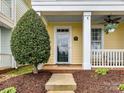 Inviting front porch with ceiling fan, room for seating, and manicured landscaping at 2003 Trigger Dr, Indian Trail, NC 28079