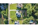 A bird's eye view of a home with lush gardens, a long driveway, and mature trees on a verdant lot at 230 Washam Rd, Mooresville, NC 28117
